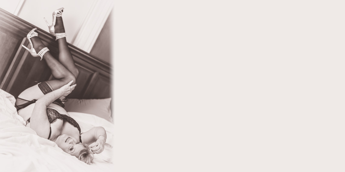 Boudoir Photo of an Women in Lingerie with Legs Up on Headboard